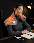 Femme avec le coussin chauffant électrique sur la nuque et les épaules