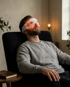 LED eye mask with red light – man wearing the mask in an armchair