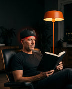 LED red light cap for the scalp – man wearing the cap while reading