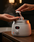 Massage oil warmer with display – hand dispensing oil from the pump head